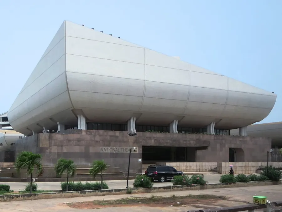 The National Theatre seen from the street, with cars and trees in front