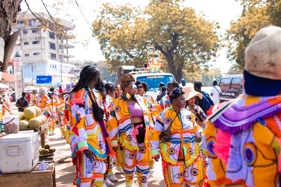 A street in Takoradi packed with masqueraders in bright patchwork costumes