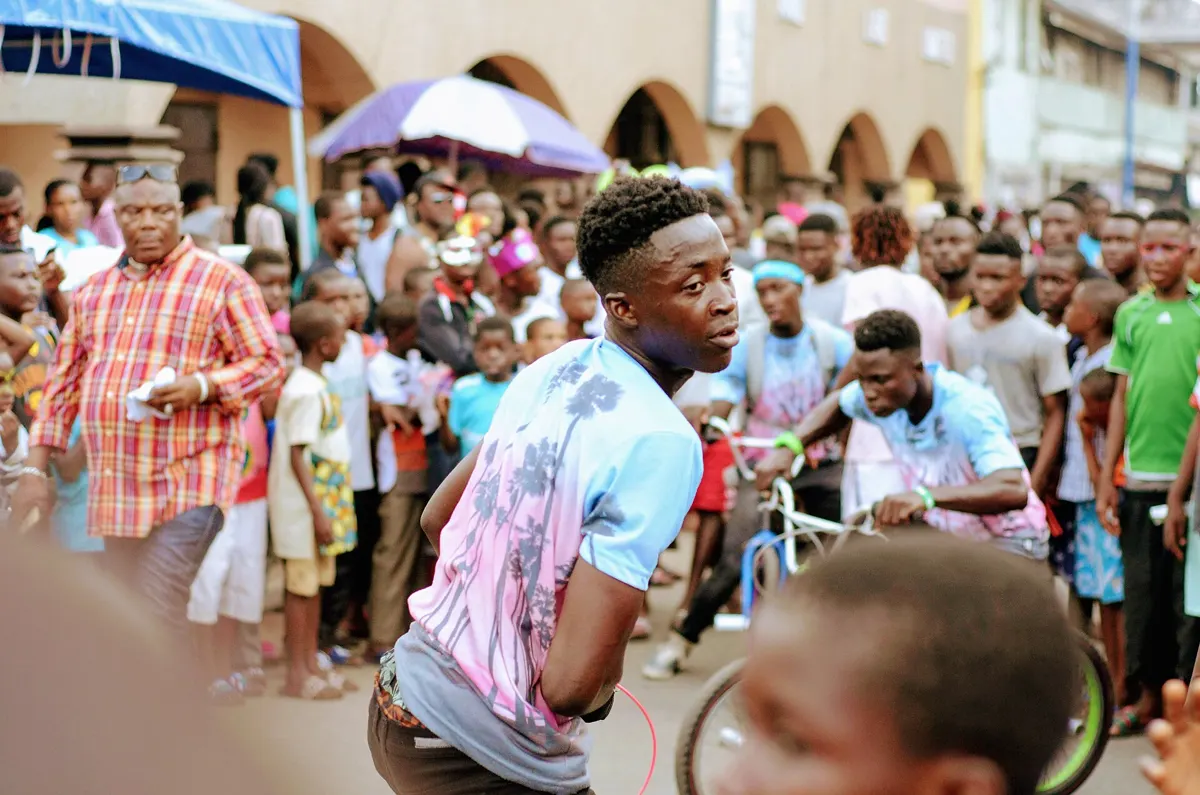 A crowd watches a street bicycle skills display at Chale Wote