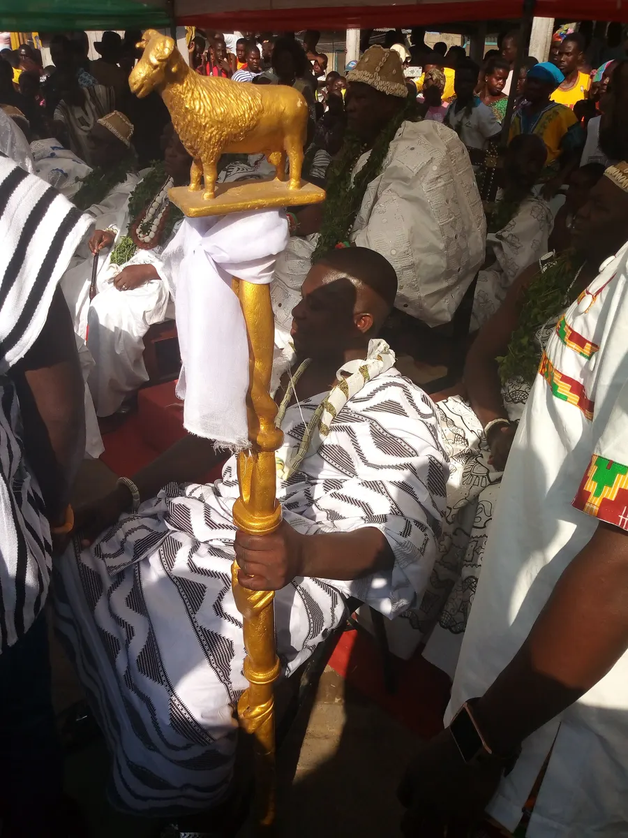 A chief’s linguist holds a gold-topped staff during the Teshie Homowo ritual on the ban on drumming