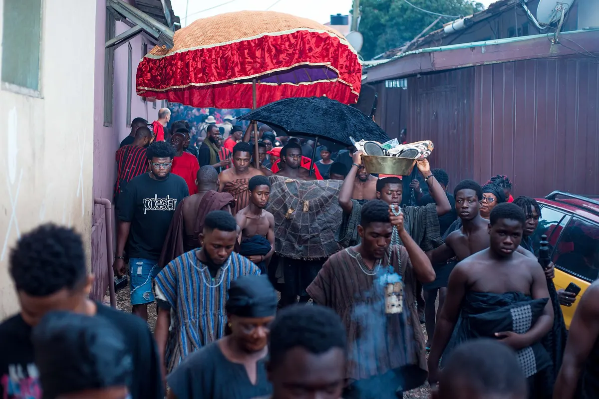 A procession under red umbrellas during the Odwira rituals